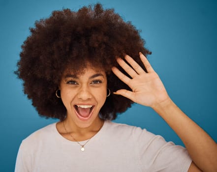 Brazilian woman, afro or surprise face on blue background in studio in waving, hi or greeting hand gesture. Portrait, smile or happy model and excited or comic facial expression and fashion hairstyle