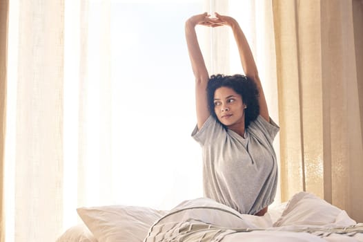 Black woman, wake up and morning stretching in home bedroom after sleeping or resting. Bed relax, peace and comfort of young female stretch after feeling fresh, awake ready to start day in house.