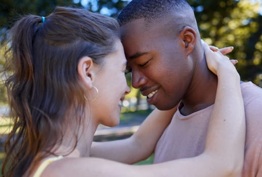 Love, park and face with an interracial couple bonding or hugging outdoor together on a romantic date in nature. Summer, romance and diversity with a man and woman dating outside in a green garden.