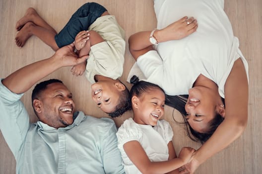 Top view, happy family or bonding on floor in house living room, family home bedroom or Indonesian hotel. Smile, children or kids with mother, father or parents lying on ground in trust, play or love.