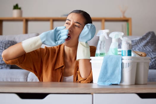 Cleaning, yawn and tired with a woman housekeeper yawning while working in a home as a cleaner. Clean, bored and hygiene with a female suffering burnout from housekeeping as a maid with disinfectant