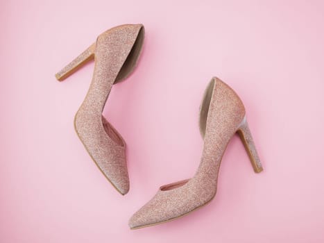 Fashion blog look. Pastel glitter golden women high heel shoes on pink background. Flat lay, top view. Minimal feminine vogue concept. Party time. Trendy beauty female backdrop.
