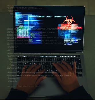Cyber security, crime and hands typing on a laptop while programming or hacking a website. Scam, cyber attack and man hacker coding on a computer to steal information or data technology in the dark.