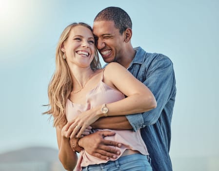 Love, diversity and couple hug on vacation, holiday or summer trip. Romantic, relax smile and happy man and woman hugging, embrace or cuddle, having fun and enjoying quality time together outdoors.