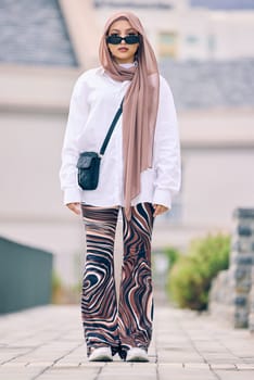 Portrait, fashion or faith with an islamic woman outdoor in a cap and scarf for contemporary style. Islam, faith and hijab with a full length trendy young muslim person outside in modern clothes