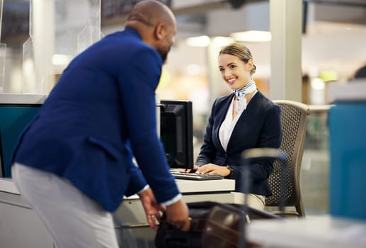 Black man, airport reception and security check with woman, concierge and help desk in lobby with luggage. African businessman, travel and immigration at inspection for international transportation