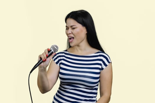 Young asian woman is singing songs with microphone.