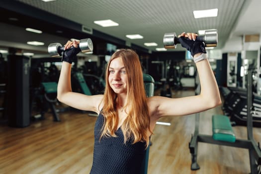 Smiling teen girl training in a fitness club, close up