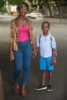 woman accompanies her son to school