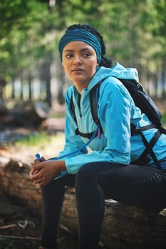 Sweat plus sacrifice equals success. an athletic young woman out for a jog in the woods.