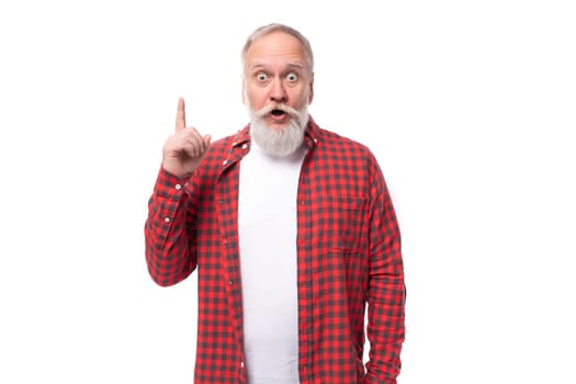 handsome genius 60s elderly man with a gray beard in a shirt has an idea