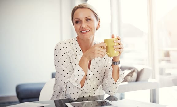 Theres nothing like a fresh cup of coffee to start the day. a mature businesswoman working from her home office.