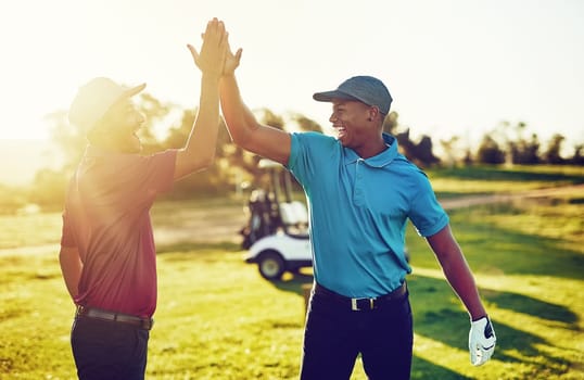 United we play, united we win. two golfers high-fiving on a golf course.