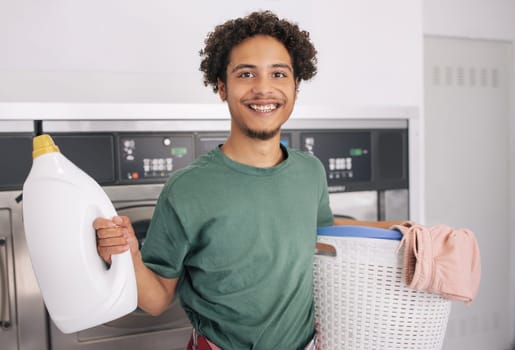 Happy Young Man Holding Basket With Clean Clothes At Laundry