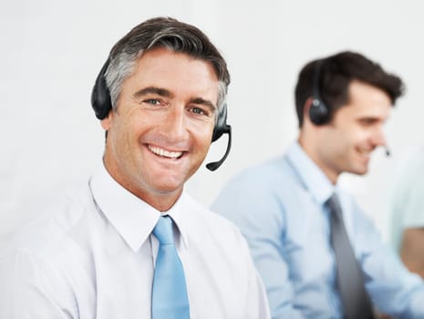 Positivity in the workplace. Male customer service agents at work while wearing headsets.