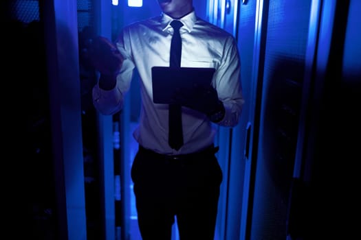 High speed internet is essential in the modern world. Closeup shot of an unrecognisable man using a digital tablet while working in a server room.