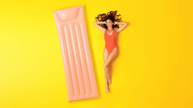 Woman In Swimsuit Lying Near Inflatable Mattress Over Yellow Background