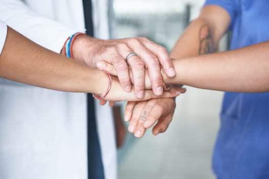 We have to keep each other strong in this industry. an unrecognizable group of healthcare professionals standing huddled together with their hands piled in the middle.