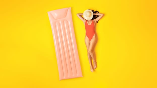 Woman In Swimsuit Posing Near Inflatable Lilo Sunbathing In Studio