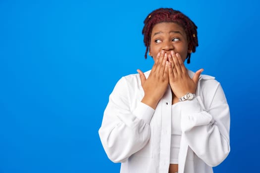 Oops Young afro woman close mouth with hands against blue background