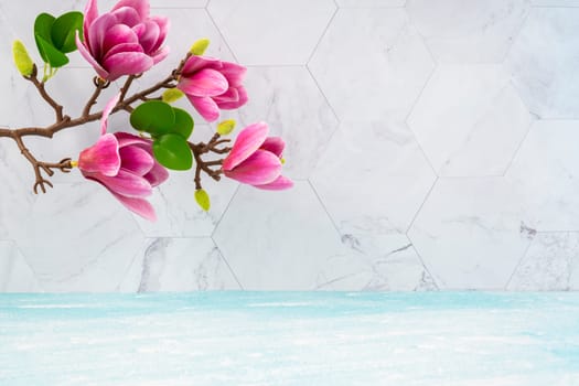 The Beautiful pink magnolia flowers on blue wooden floor and marble background with copy space for your design.