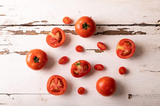 Overhead view of fresh tomato variations on white wooden table