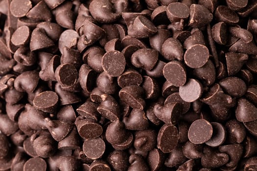 Full frame close-up view of fresh chocolate chips pile. unaltered, sweet food and unhealthy eating concept.