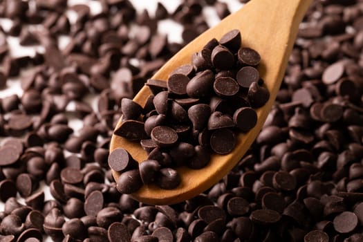 Close-up of fresh chocolate chips with wooden spoon