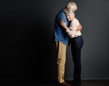 Sharing a loving embrace. Studio shot of an affectionate senior couple posing against a grey background.