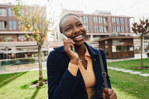 Female african student talking on the phone near the university campus