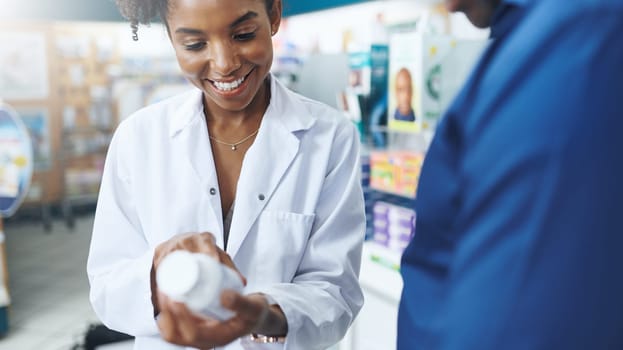 She does more than just get medication from a shelf. a female pharmacist assisting a customer in a drugstore.