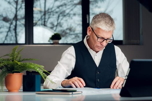Mature businessman working at the desk in office.