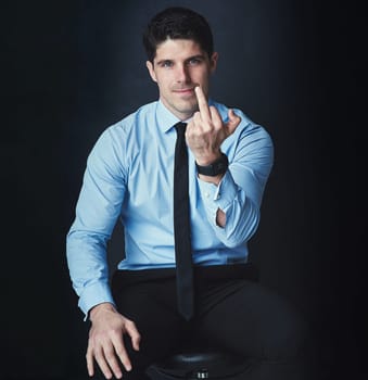 I didnt ask for your useless opinion. Studio portrait of a young businessman showing the middle finger against a dark background.