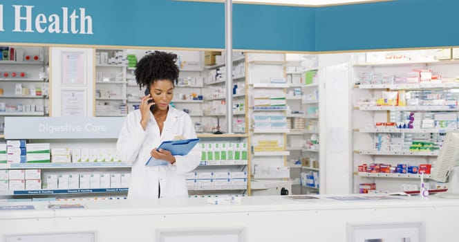 I will commence your refill immediately. an attractive young pharmacist looking at a file while on a phonecall.
