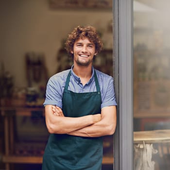 Retail, arms crossed and portrait of man at restaurant for small business, coffee shop and waiter. Entrepreneur, happy and smile with male barista at front door of cafe for diner and food industry.