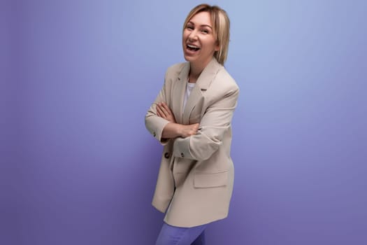 positive 30 year old woman in a jacket with blond hair on a studio background with copy space