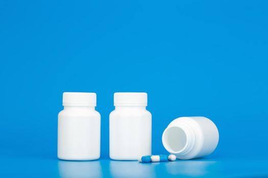 White medication bottles with spilled pills. Concept of healthcare and medical treatment