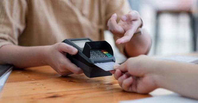 Customer using credit card for purchase to waitress EDC at cashier, Credit card payment concept