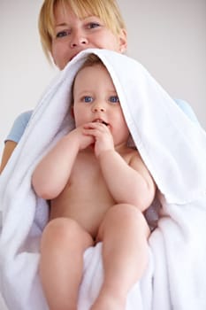 Baby, towel and portrait with care for mother with comfort or love in a closeup or family home. Mom, hug and holding an infant for bath with cleaning or affection at house for hygiene with happy kid.