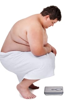 Scale, plus size and man checking number and weight loss progress in a studio. White background, male person and profile of a heavy set model looking at health and wellness results with a towel