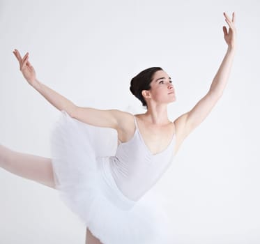 Music, dance and ballet with a woman in studio on a white background for rehearsal or recital for theatre performance. Art, creative and focus with a young female ballerina or dancer in uniform.