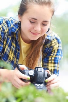 Woman, camera and photography in nature for plant, leaves and growth in garden, park and summer sunshine. Girl, photographer and travel in countryside with focus, memory and outdoor with plants.
