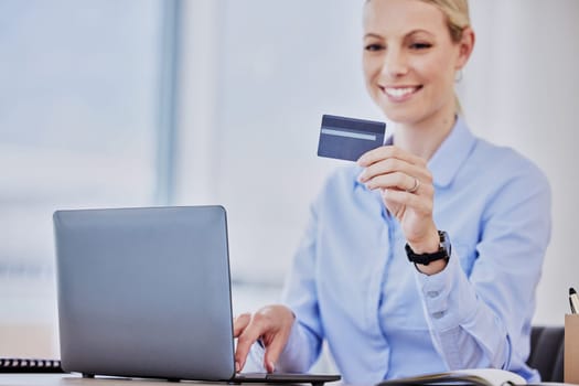 Business woman, laptop and credit card with online shopping, smile and cybersecurity at desk. Young female entrepreneur, e commerce and happy with payment, password or info for discount, sale or deal