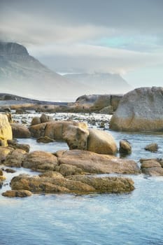 Ocean, rocks and landscape with beach and outdoor, travel with summer vacation in South Africa. Environment, seaside location and tropical destination with journey to sea and nature with adventure