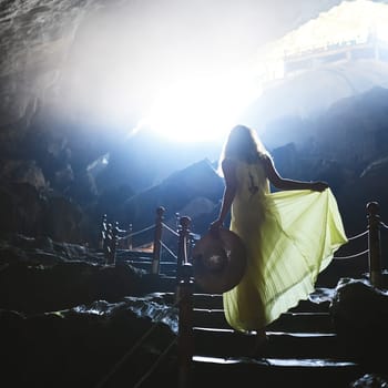 In darkness, let your soul light the way. a young woman walking up steps in a Vietnamese cave.