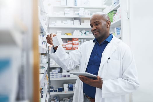 I always consult with my partners in healthcare online. a pharmacist using a digital tablet in a chemist.