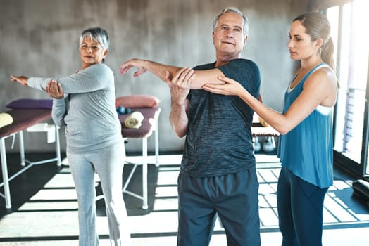 Stretching, physical therapy and old man with personal trainer for fitness, wellness or helping. Health, workout or retirement with senior patient and physiotherapist in class for warm up training