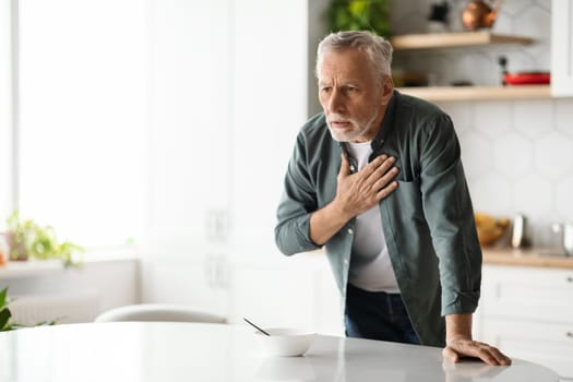Heart Attack. Senior man suffering from chest pain at home