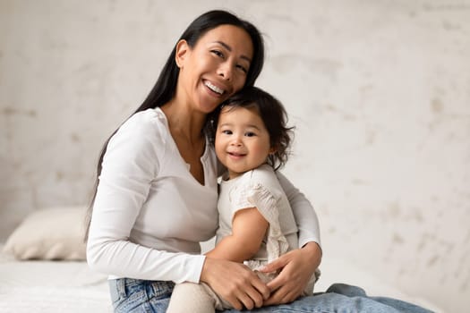 Asian Mom And Baby Sharing Warm Embrace Posing At Home
