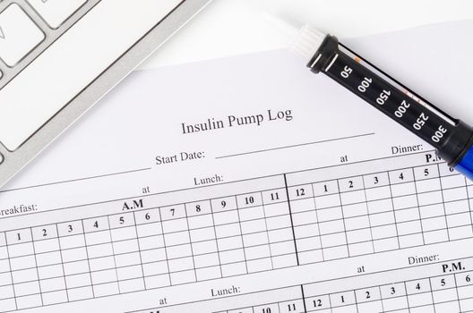Insulin pump log record form and syringe wiht insulin.